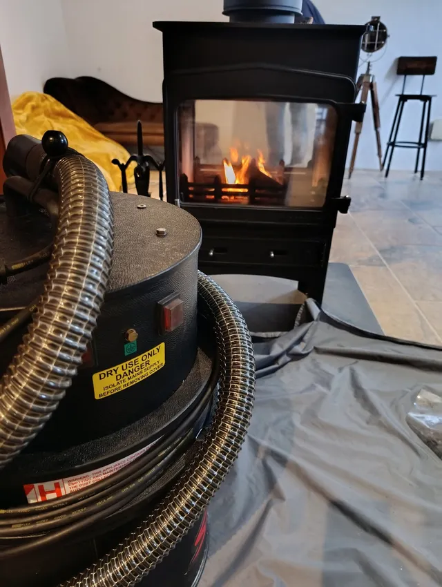 Jack's vacuum in front of a lit wood burner